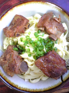 八重食堂のソーキそば。スープが入っていない麺の上にソーキとカマボコがのっている
