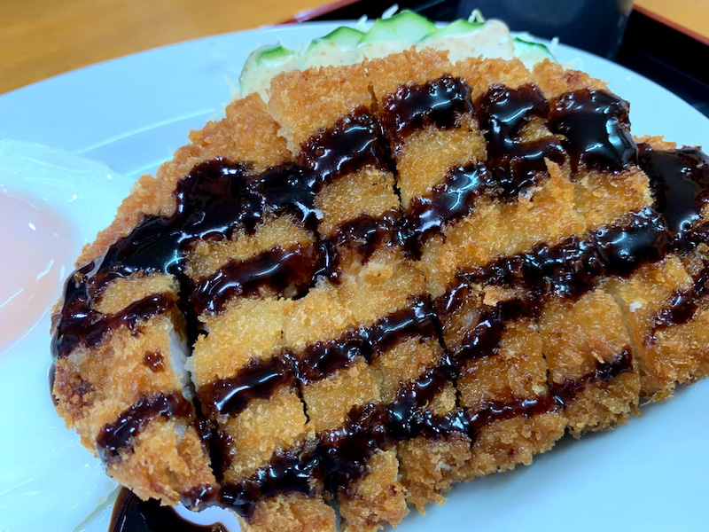 とんかつにソースをかける様子
