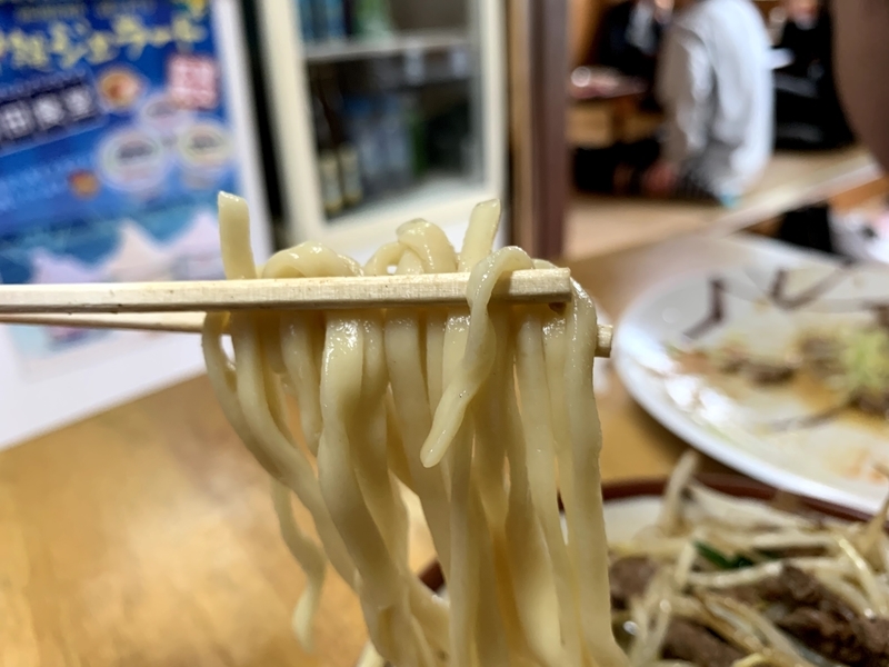 箸で持ち上げた太めのもちもち麺