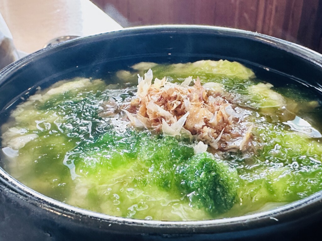 ゆし豆腐のアップ。ふわふわの豆腐の上にアーサーと花かつおがたっぷりのっている