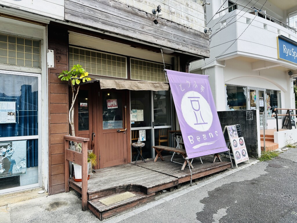 首里の通り沿いにある「とうふ屋 Beans」の入り口。紫の暖簾が目印の落ち着いた佇まい