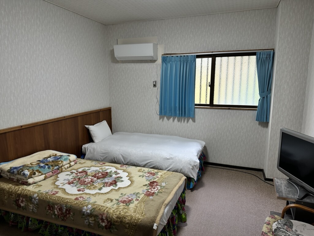 いずみ荘の客室。ベッドが複数置かれた洋室
