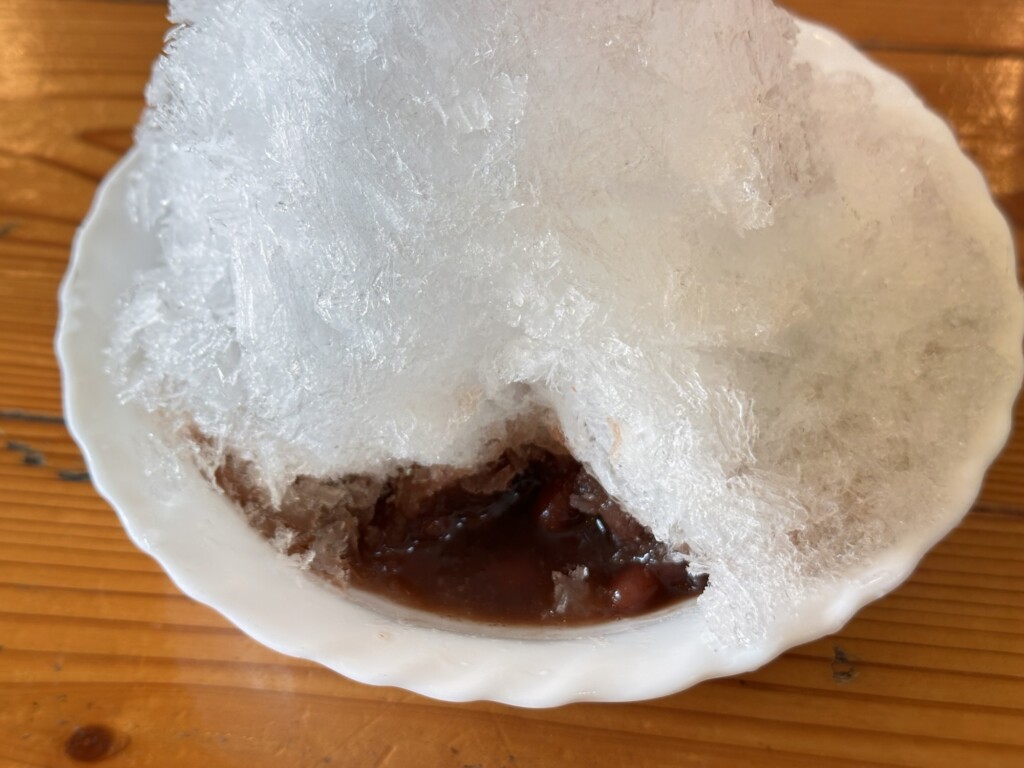 真っ白な氷をスプーンで掘ると、中から茶色の金時豆が見えてきた様子