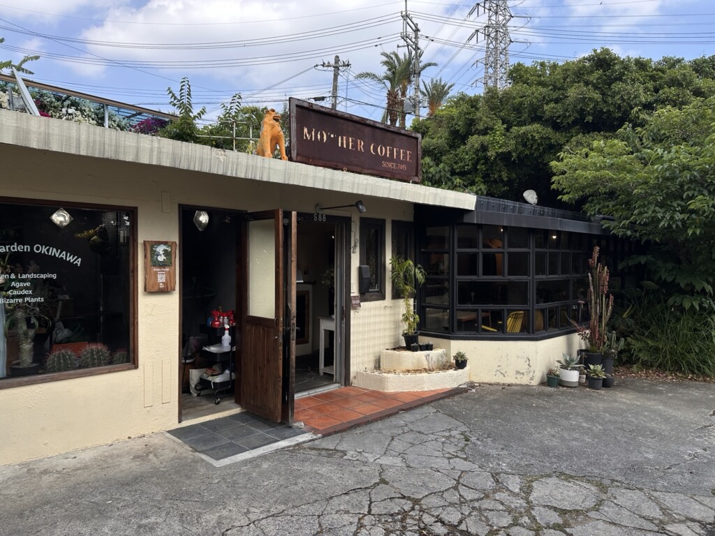Mother coffeeの白い壁と木製看板の外観