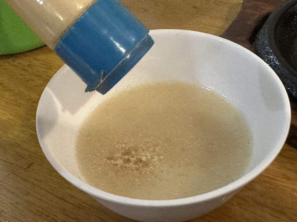 スープにコショウを振る様子。