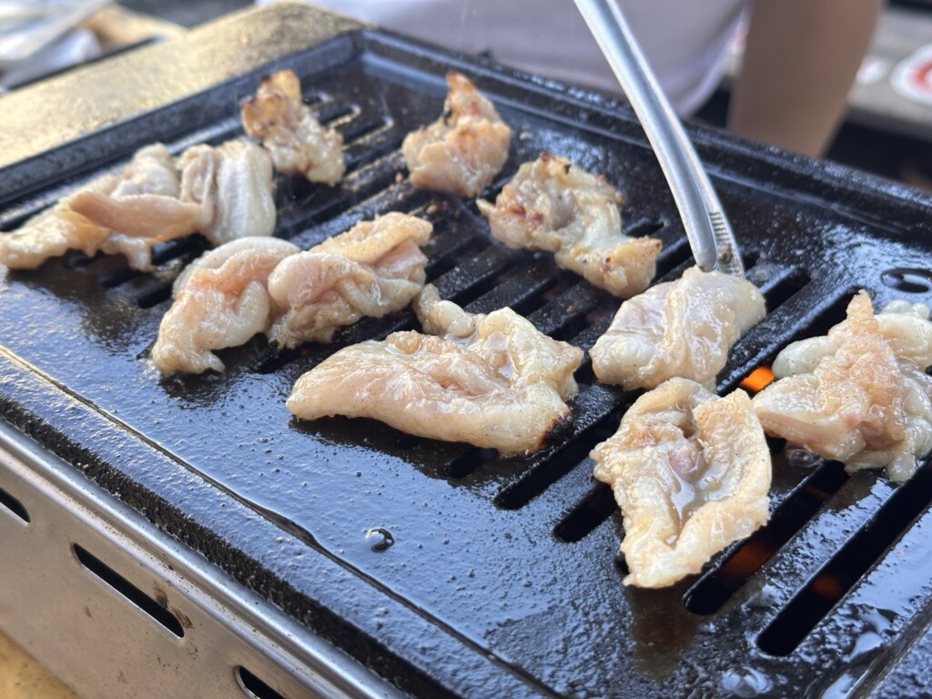 焼き上がった鶏肉を箸で持ち上げる様子