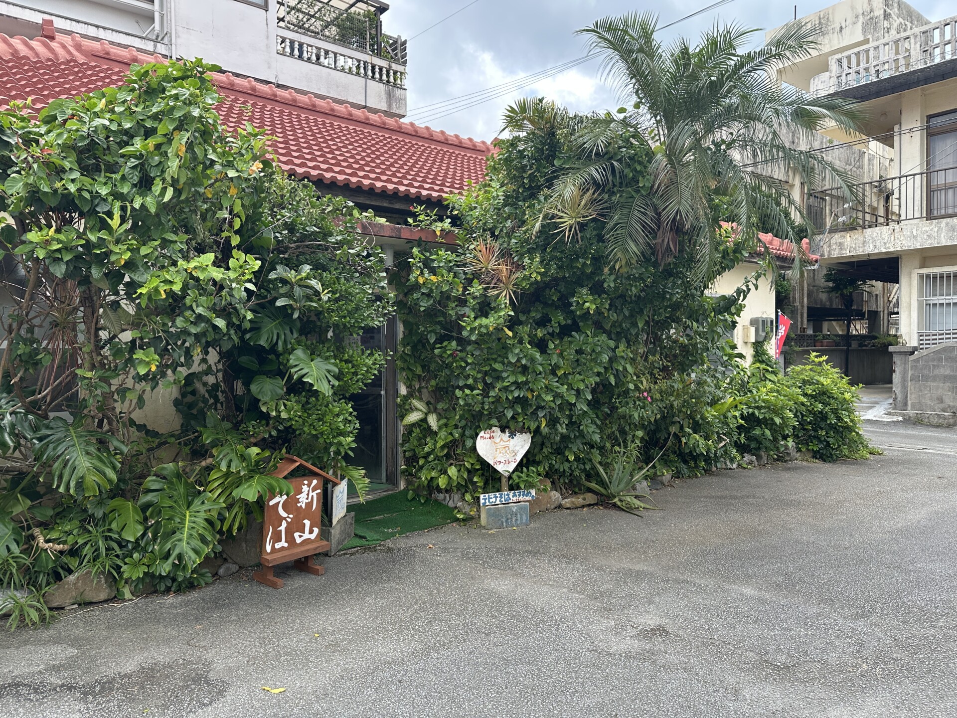 新山そばの赤瓦の屋根と木製の看板