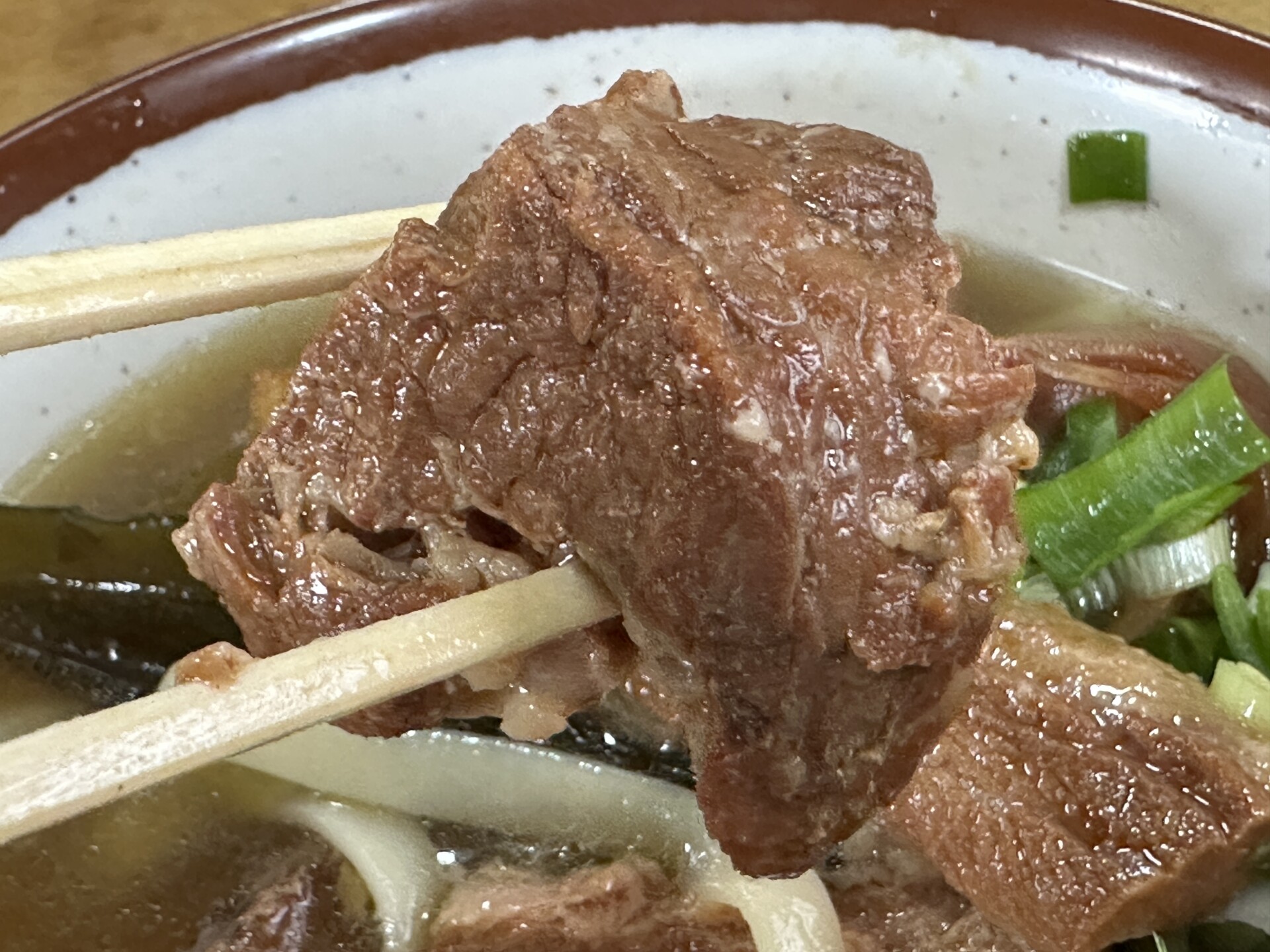 柔らかく煮込まれたソーキの箸持ち上げ