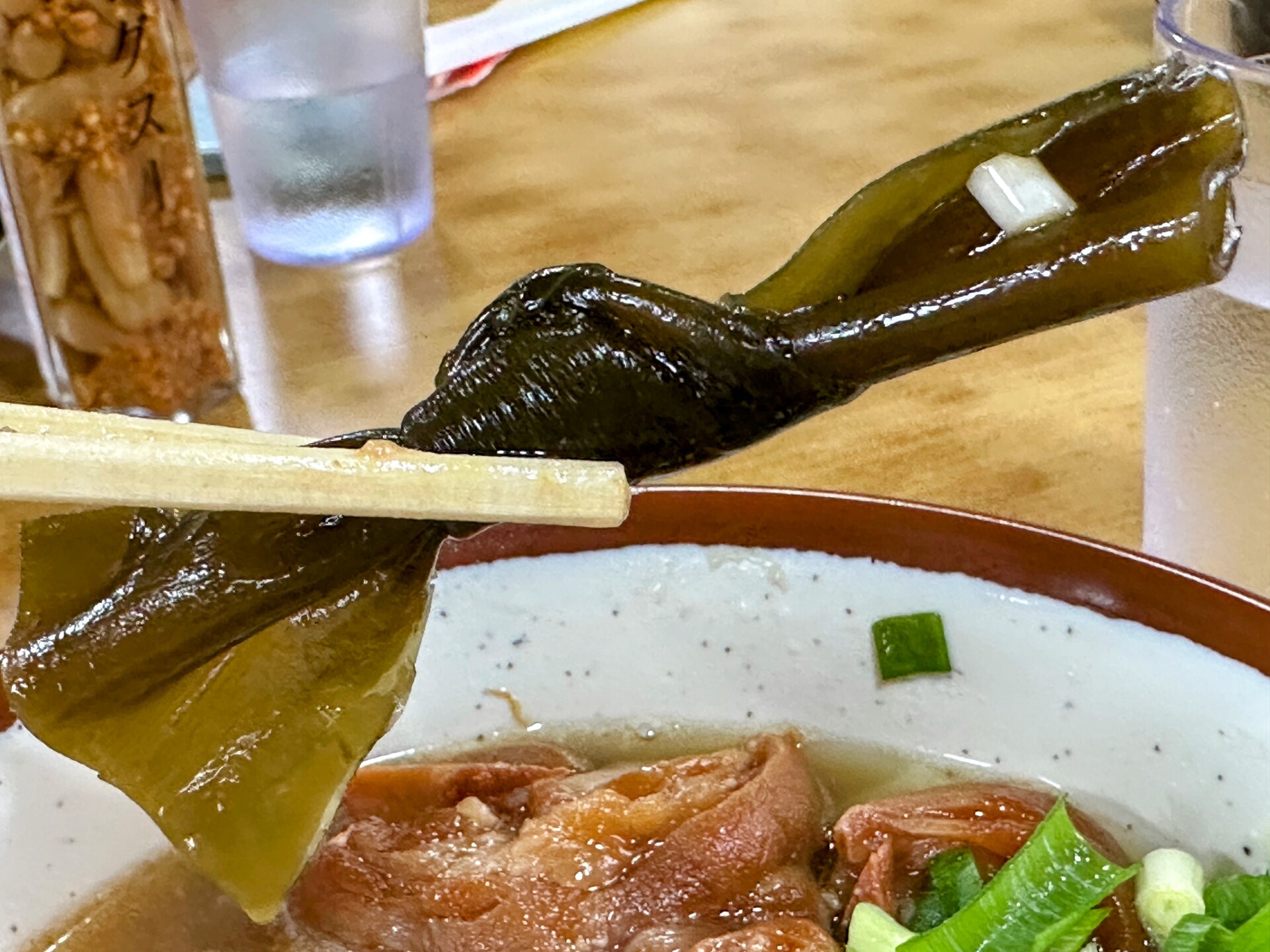 沖縄そばの上に乗った結び昆布の箸持ち上げ