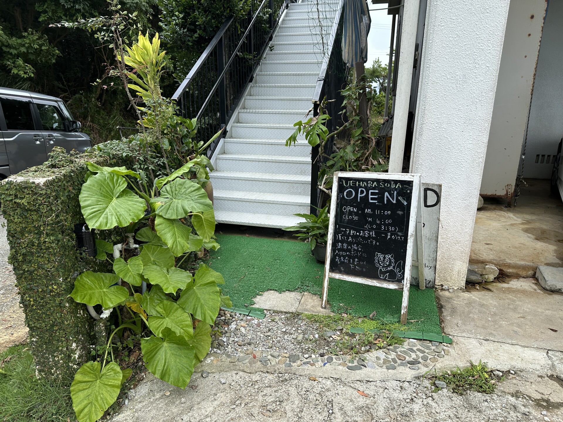 上原そば 階段下の案内看板とシーサー