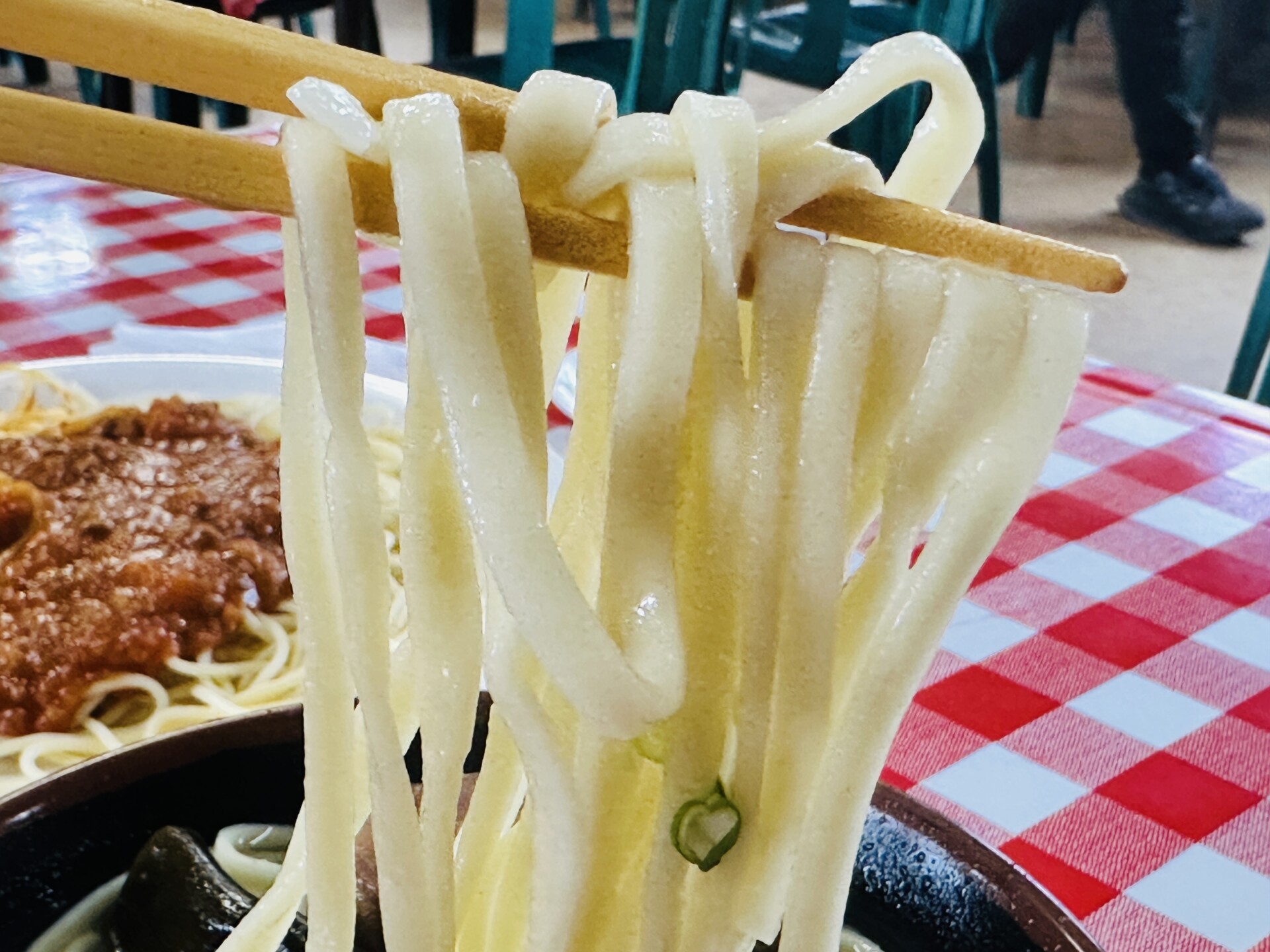 スープが絡んだ平打ち太麺の持ち上げショット