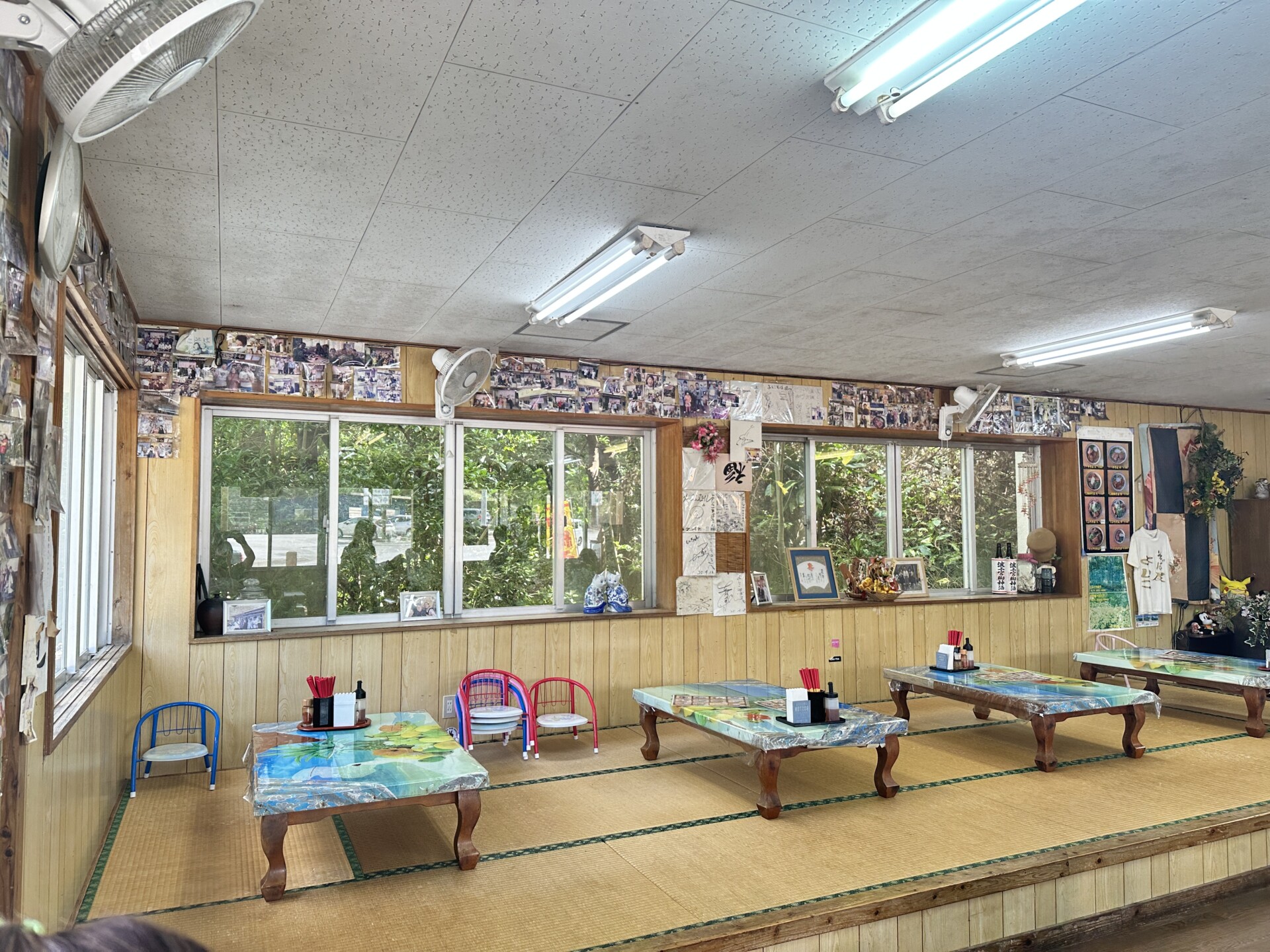 畳の小上がり座敷席と壁一面の写真が並ぶそば屋よしこの店内