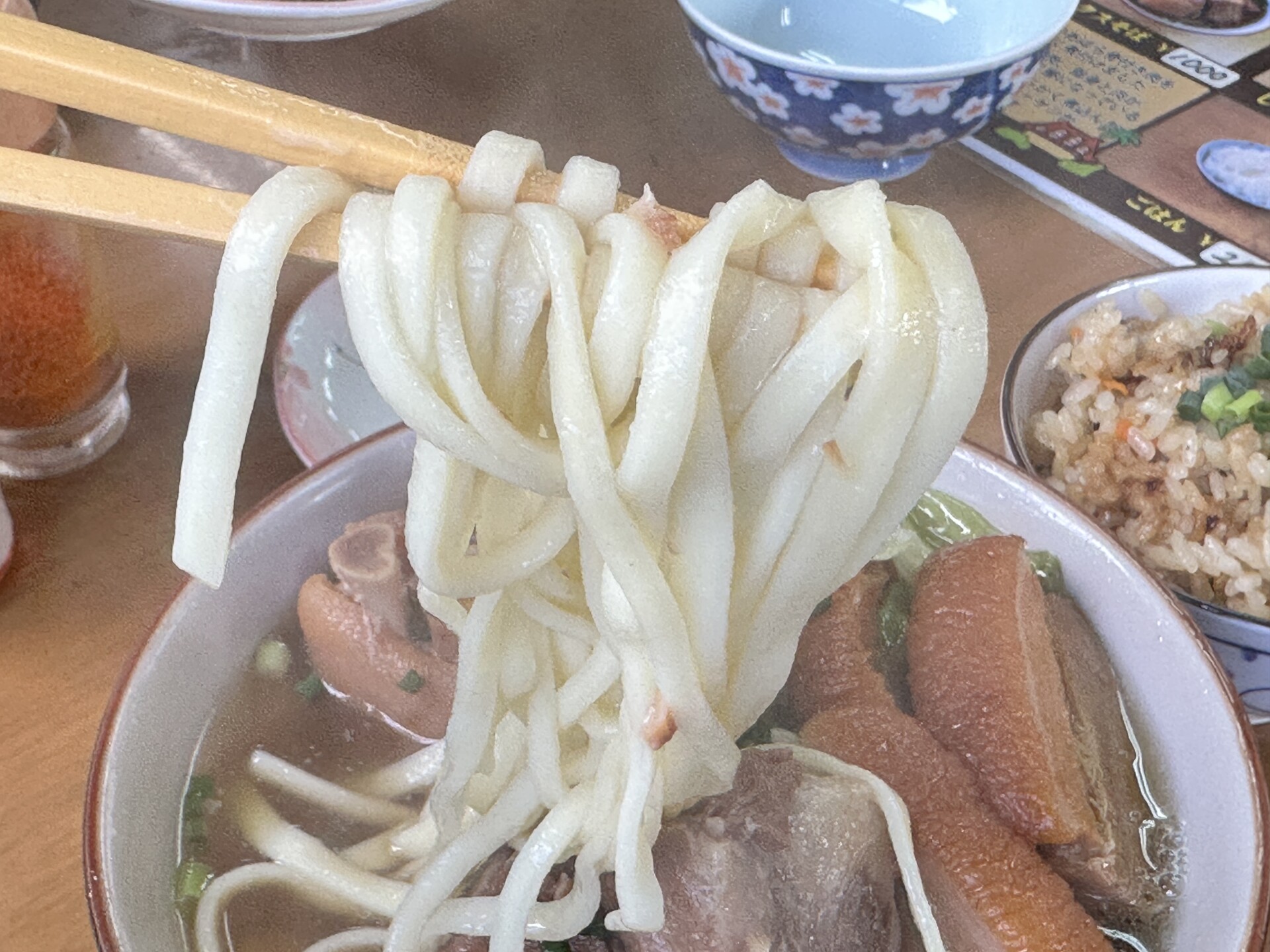 少しちぢれの入ったコシのある平打ち太麺の箸上げ